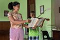 Director Wilma Ynez holding the score for 11 year old Abdoo, a Yemeni student.<br />"Lauro Fuentes" Community Music School <br />Nov. 1, 2016 - Santiago de Cuba.