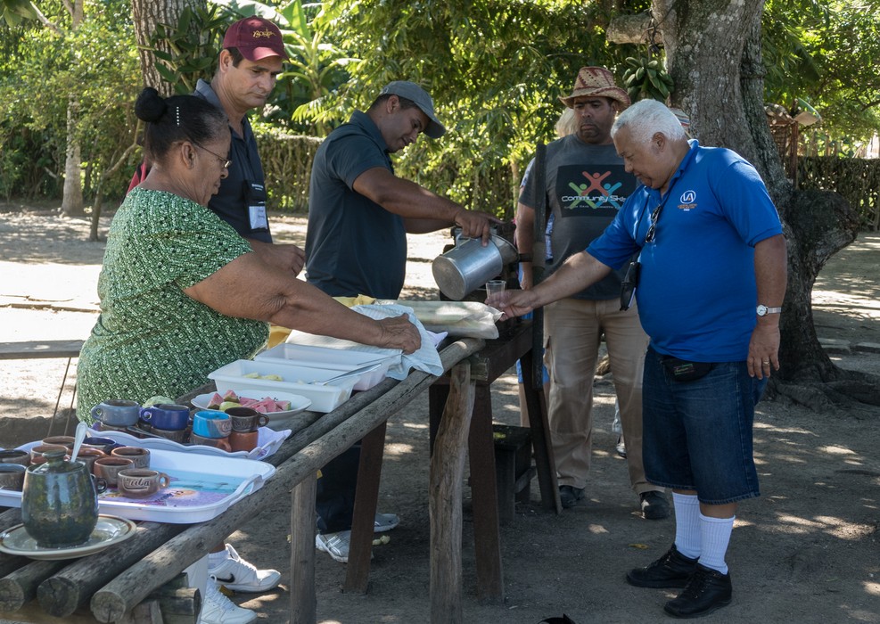 Juana, Osmar, a couple of local men, and Eddie being served sugar cane juice.<br />Nov. 4, 2016 -Village near Rancho King, Camag�ey, Cuba.