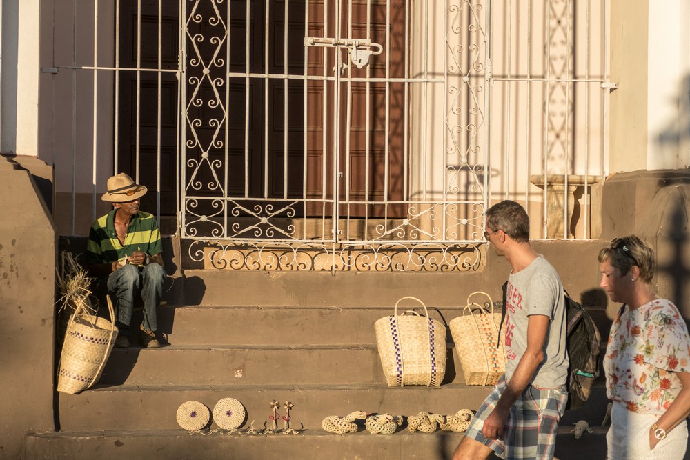 A basket weaver displaying his wares on the steps of the Holy Trinity Church.<br />Nov. 5, 2016 - Plaza Mayor, Trinidad, Cuba.